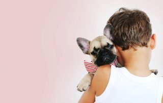 Boy Holding his puppy - brushing your dog's teeth concept image